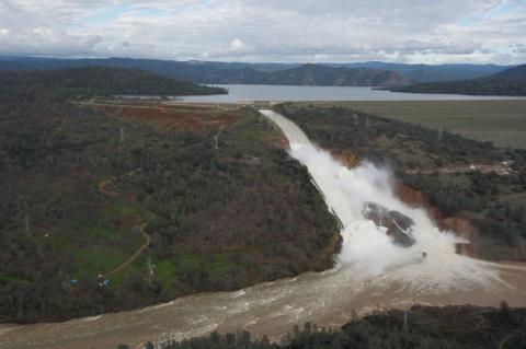 Water rapidly flows from the eroded Oroville Dam spillway in February 2017. The large gully to the right was caused by water cascading through a broken and damaged concrete surface. Photo courtesy of the California Governor’s Office of Emergency Services. 
