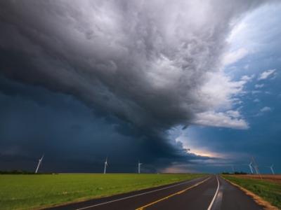 Photograph of a storm over a road and wind turbines